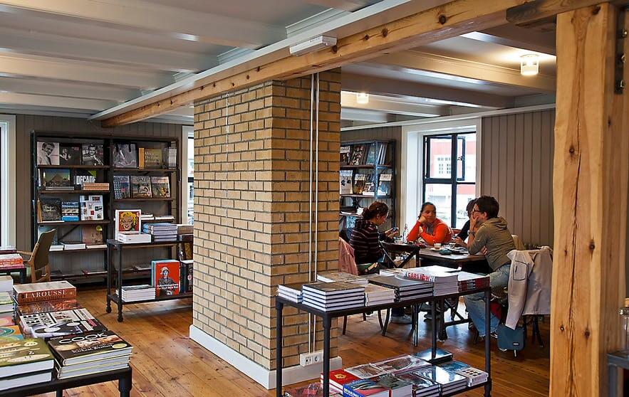 People drinking coffee at the Ida Zimsen bookshop cafe in Reykjavik, Iceland